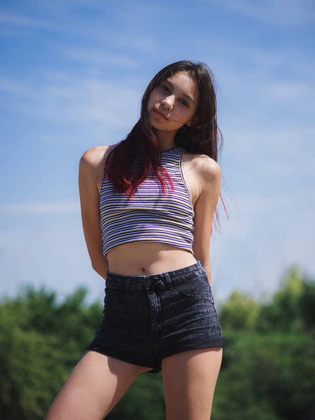 A portrait of a charming teenage girl in summer clothes posing on a natural background. Fashion, youth concept. Copy space. - Fotoğraf, Görsel