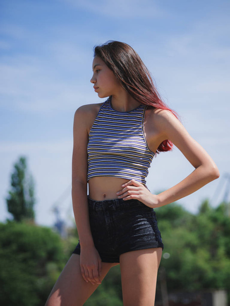 A portrait of a charming teenage girl in summer clothes posing on a natural background. Fashion, youth concept. Copy space. - Foto, Bild