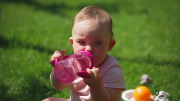 Un bambino beve acqua da una bottiglia di plastica per bambini
 - Filmati, video