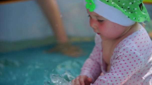 Un bambino sta giocando nella piscina per bambini, pagaia sull'acqua
 - Filmati, video