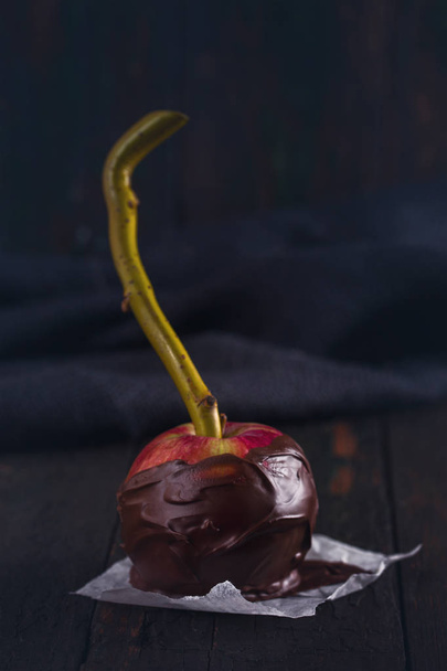 Uma maçã vermelha em chocolate preto
 - Foto, Imagem