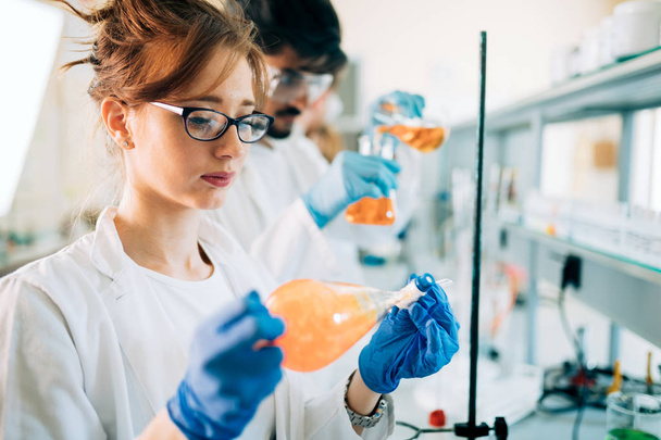 Young students of chemistry working in laboratory - Zdjęcie, obraz