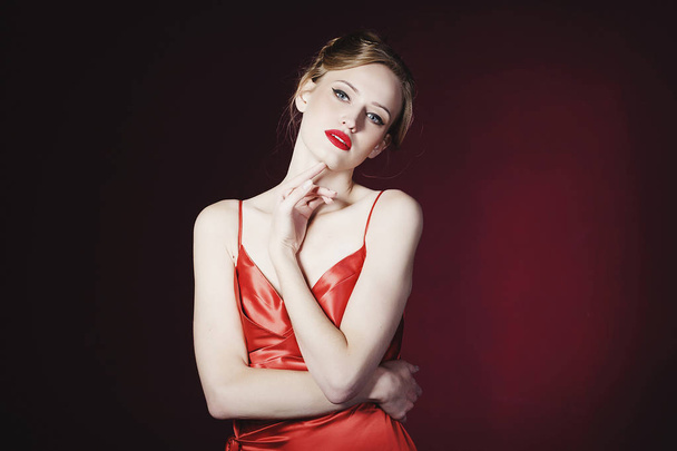 Young beautiful blond woman in red dress over red background. Fa - Foto, imagen