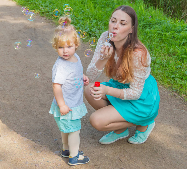 soap bubbles on a walk allowed the mother and child. - Photo, image
