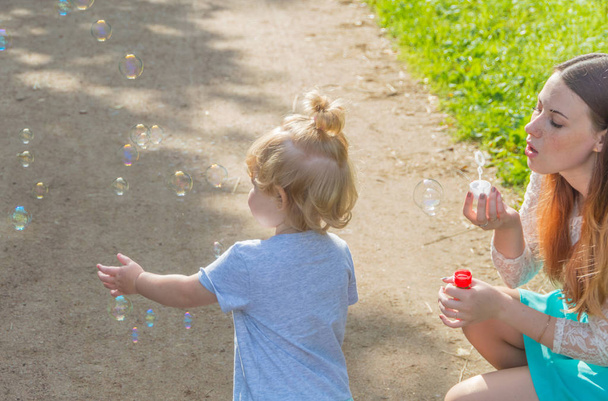 walking, baby and mommy blow bubbles. - Foto, afbeelding