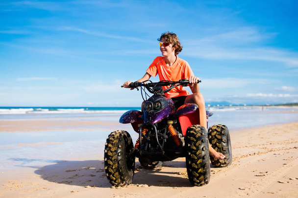 Teenager riding quad bike on beach - Photo, Image