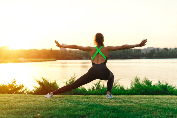 Meditation Mädchen auf dem Meer während des Sonnenuntergangs. Yoga-Silhouette. Fitness und gesunder Lebensstil. - Foto, Bild