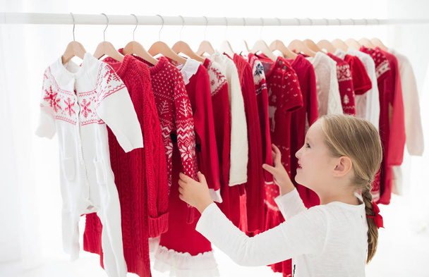 Стійка для одягу з червоним різдвяним трикотажем
 - Фото, зображення
