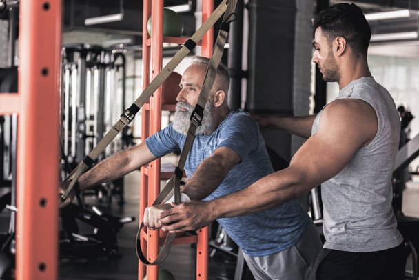 Stylish pensioner is having workout with young instructor - Photo, Image