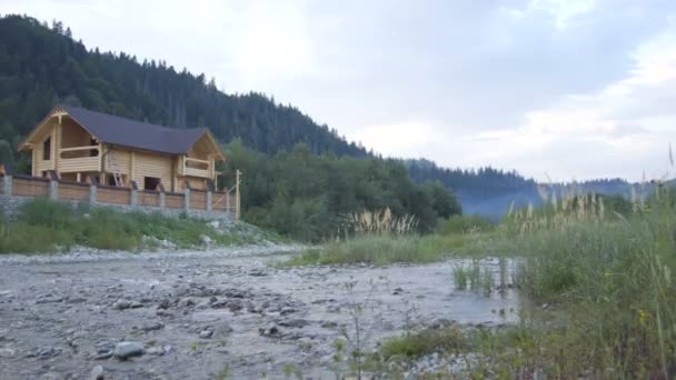 Un río de montaña fluye a lo largo del bosque y una hermosa casa de madera
 - Imágenes, Vídeo