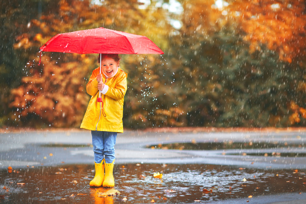 niña feliz con un paraguas y botas de goma en charco en
 - Foto, Imagen