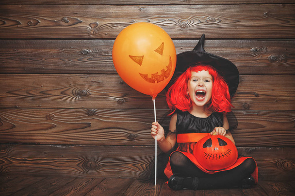 funny child girl in witch costume in hallowee - 写真・画像