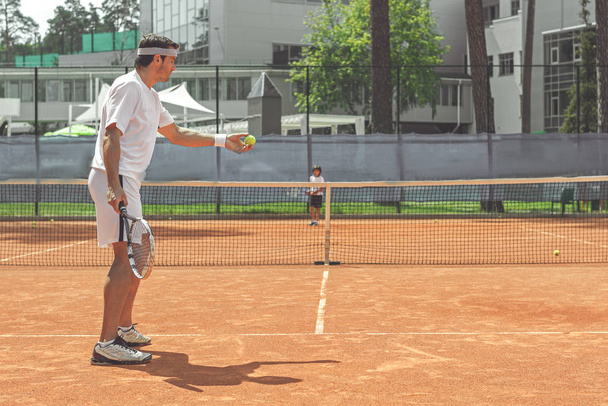 Adult sportsman having game with kid at court - Fotoğraf, Görsel