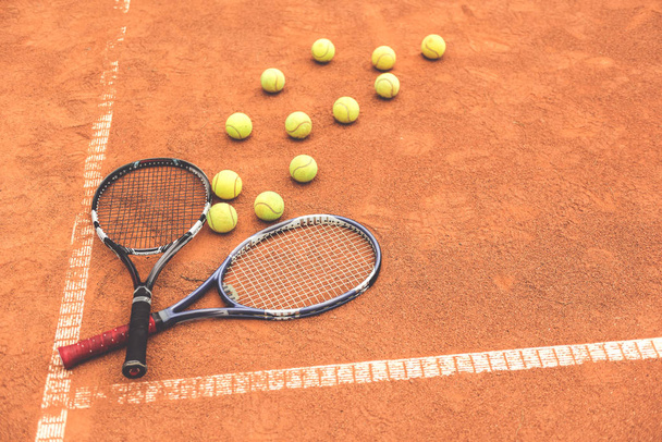 Necessary racquets beside yellow round spheres - 写真・画像