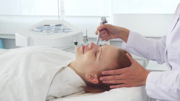 Cosmetologist χρησιμοποιώντας κάποιο εξοπλισμό στο πρόσωπό τους πελάτες - Πλάνα, βίντεο