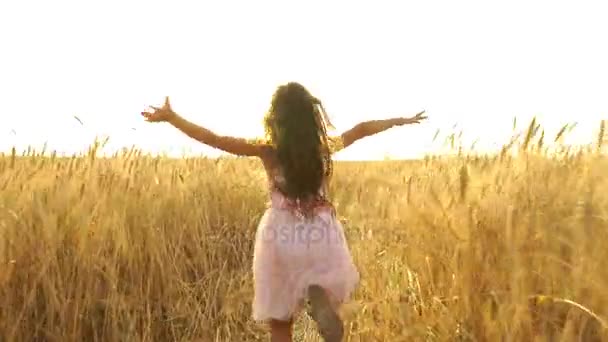 mladá dívka v šatech běží přes pole. - Záběry, video