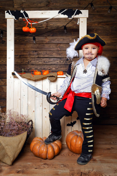 Funny boy in pirate costume in the studio with scenery for Halloween - Foto, imagen