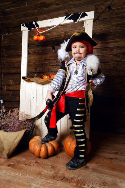 Funny boy in pirate costume in the studio with scenery for Halloween - 写真・画像