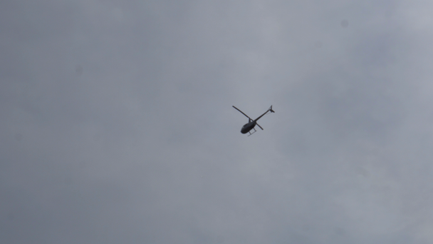 helikopteri lentää yli maan taustalla kirkas taivas
 - Materiaali, video