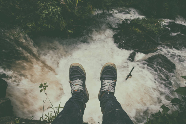 滝を一人で見てる男。足を見下ろす,選択的な焦点 - 写真・画像