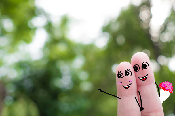 El arte del dedo de una pareja feliz. Un hombre y una mujer se abrazan con corazones rosados en los ojos.funny-finger-people-couple-smiling
 - Foto, Imagen
