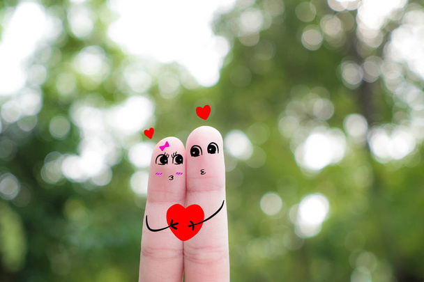 Sztuka palcem szczęśliwa para. Mężczyzna i kobieta przytulić z różowe serca w oczach .funny palec ludzie - para-uśmiecha się - Zdjęcie, obraz