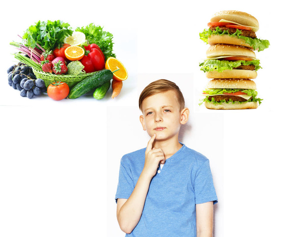 szőke fiú úgy dönt, egészséges élelmiszer- és gyorsétterem között - Fotó, kép