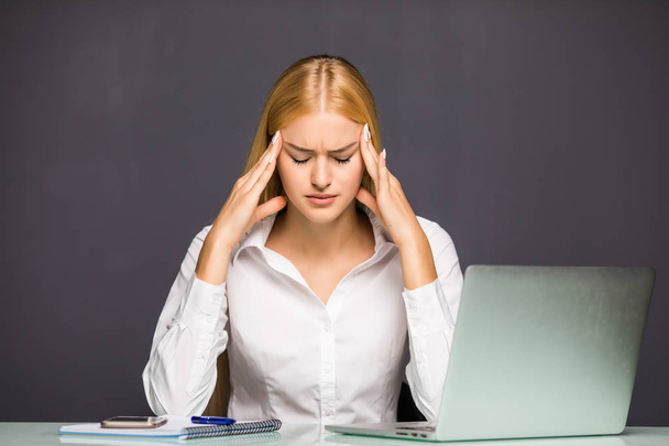 Porträt einer müden jungen Frau mit Kopfschmerzen Geschäftsfrau mit Laptop im Büro - Foto, Bild