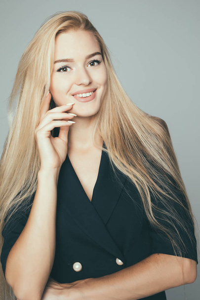 Beauty Woman face Portrait. Beautiful model . Blonde female looking at camera and smiling on gray background. - Zdjęcie, obraz
