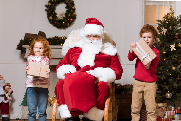 Weihnachtsmann und Kinder mit Geschenken - Foto, Bild