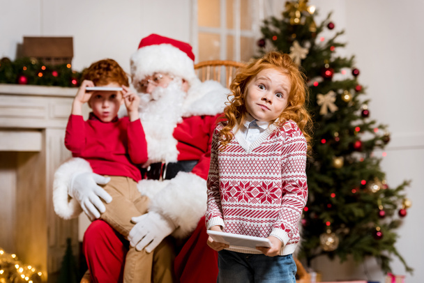 Santa Claus y niños con dispositivos digitales
 - Foto, Imagen