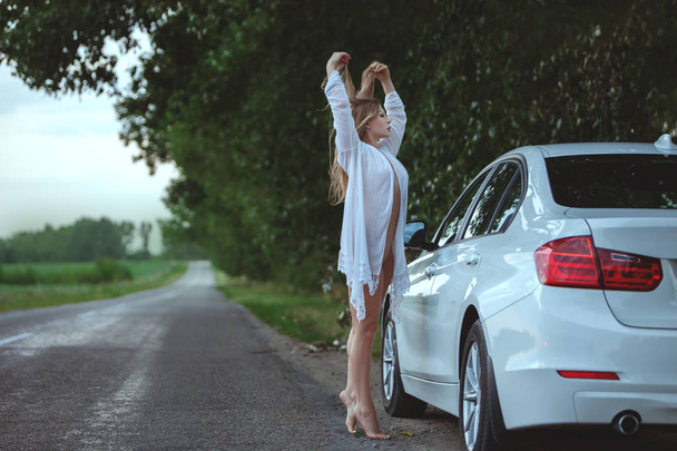 Erotyczne kobieta pozuje z samochodu. - Zdjęcie, obraz