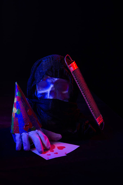 Un bodegón colorido de un cráneo artificial y una estatua de la cara femenina. Luces de estudio azules y rojas y composición artística
 - Foto, Imagen