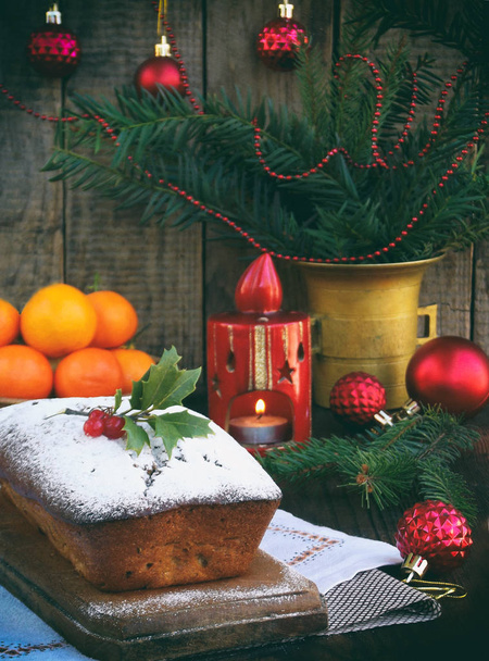 Tradycyjne świąteczne ciasto owocowe urządzone z cukrem pudrem i mas dekoracje, świeca. miejsce. Styl rustykalny. Selektywny fokus - Zdjęcie, obraz
