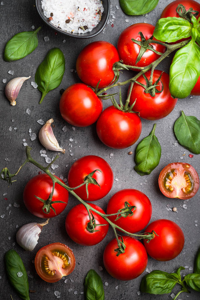 frische Tomaten auf schwarzem Schiefer Hintergrund. - Foto, Bild