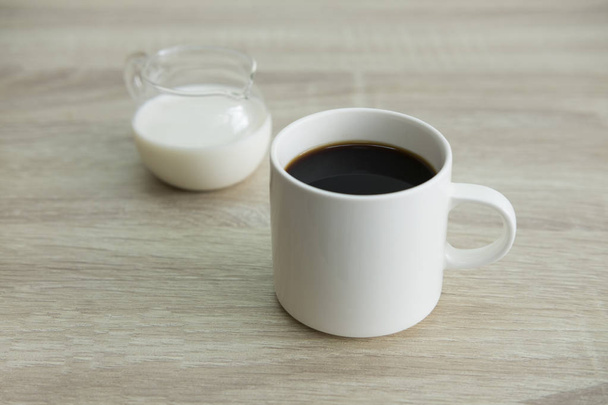 Tazza di caffè bianca con barattolo di latte
 - Foto, immagini