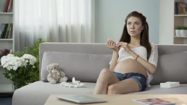 Future mother using tissues to blow stuffy nose, feeling her forehead, cold - Filmati, video