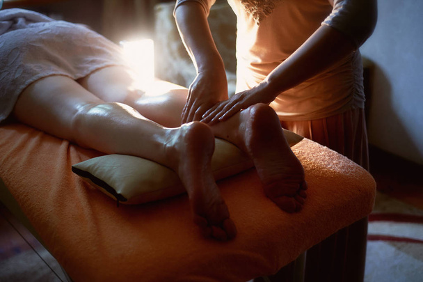 Foot massage in the spa salon.Close up of female feet during traditional Thai massage - Фото, изображение