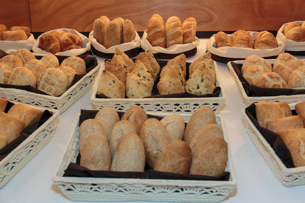 Sortimento de pão dentro de cestas brancas
 - Foto, Imagem