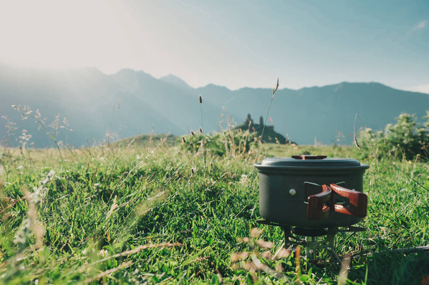 Cooking in the mountain hike on a gas burner in a bowler hat  - Photo, Image