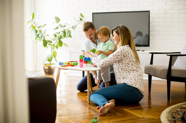 Pequeño niño jugando juguetes con la madre y el padre en casa
 - Foto, imagen