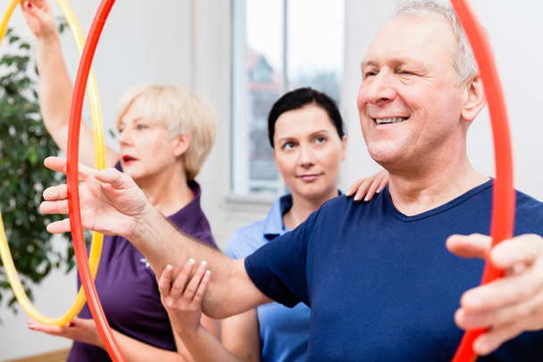 Coppia anziana in fisioterapia facendo esercizio con hula hoop
 - Foto, immagini