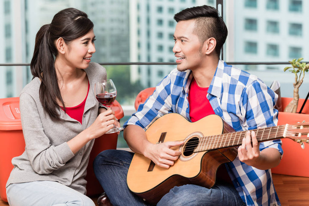 Après avoir déménagé ensemble jeune homme joue chanson d'amour pour sa petite amie
 - Photo, image