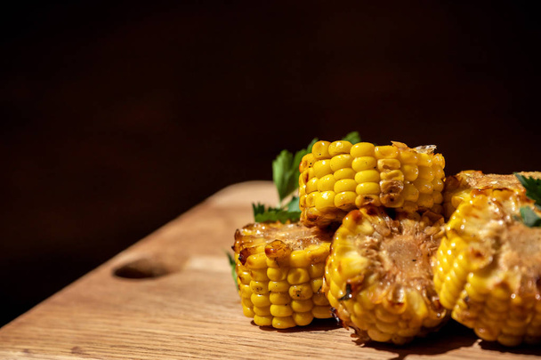 Grilled corn with herbs placed on a wooden table. - Foto, Bild