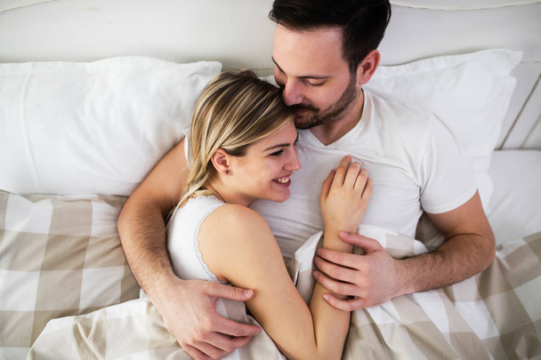 Beautiful woman and attractive man lying on bed - Fotoğraf, Görsel