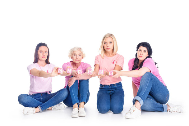 vrouwen in roze t-shirts met kanker inscriptie - Foto, afbeelding