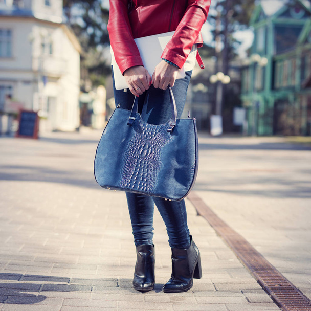 Femme élégante avec sac de mode et bottes debout sur la rue
 - Photo, image