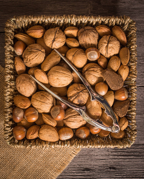 délicieux assortiment de noix dans un panier tissé sur fond en bois
 - Photo, image