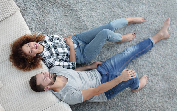 above newlyweds lying on the carpet in a new apartment - Φωτογραφία, εικόνα