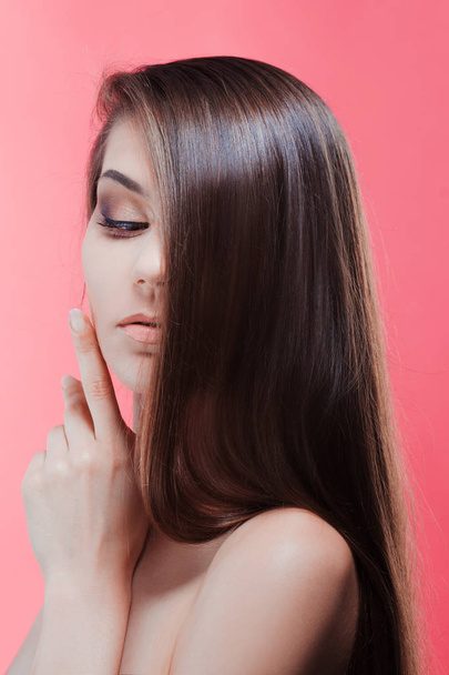 Beauty portrait of brunette with perfect hair, on a pink background. Hair care - Фото, изображение